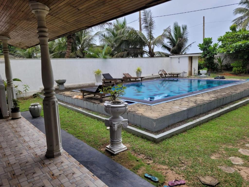 einen Pool im Garten mit Terrasse in der Unterkunft Villa sea spray in Hikkaduwa