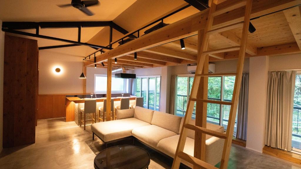 - un salon avec un canapé et une mezzanine dans l'établissement Hotel Re:Plug, à Kōchi