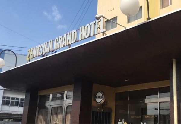 a building with a sign on top of it at Zentsuji Grand Hotel in Zentsuji
