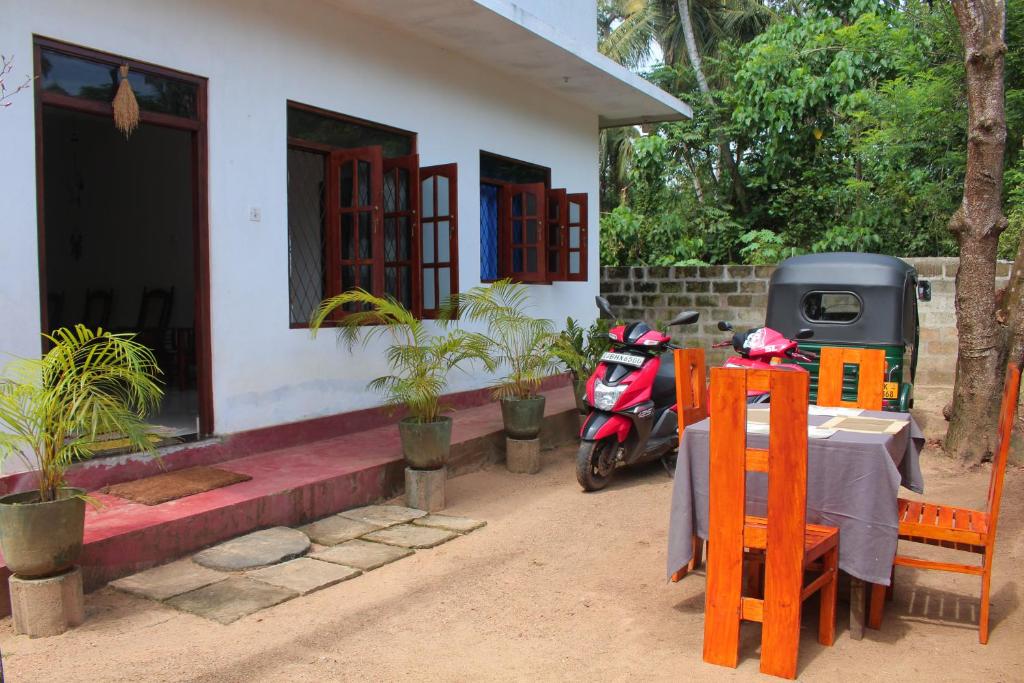 a motorcycle parked in front of a house with a table at Mango House in Talalla