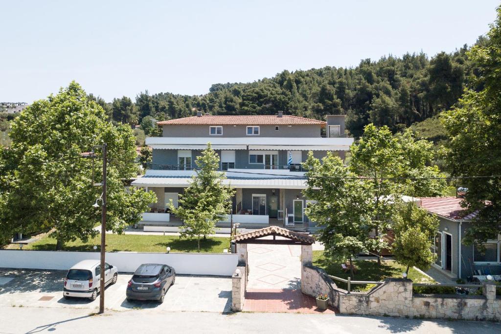 a large house with cars parked in a parking lot at Istira in Possidi