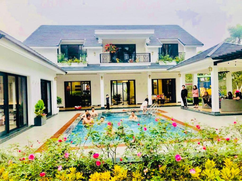 un grupo de personas en una piscina en una casa en Sapphire Villa - Venuestay en Luong Son