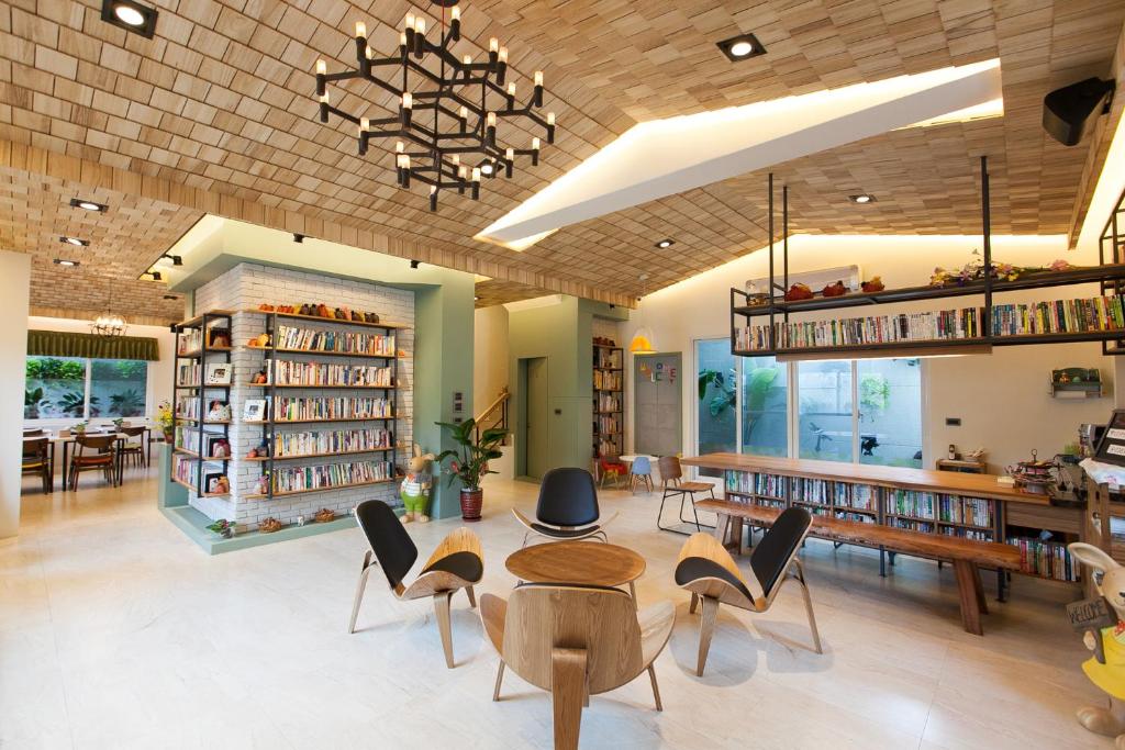 a library with tables and chairs and bookshelves at 坡岸長堤民宿 Leveeside House in Hualien City