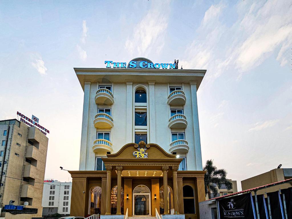 een hoog gebouw met een bord erop bij Hotel The S Crown in Somnath