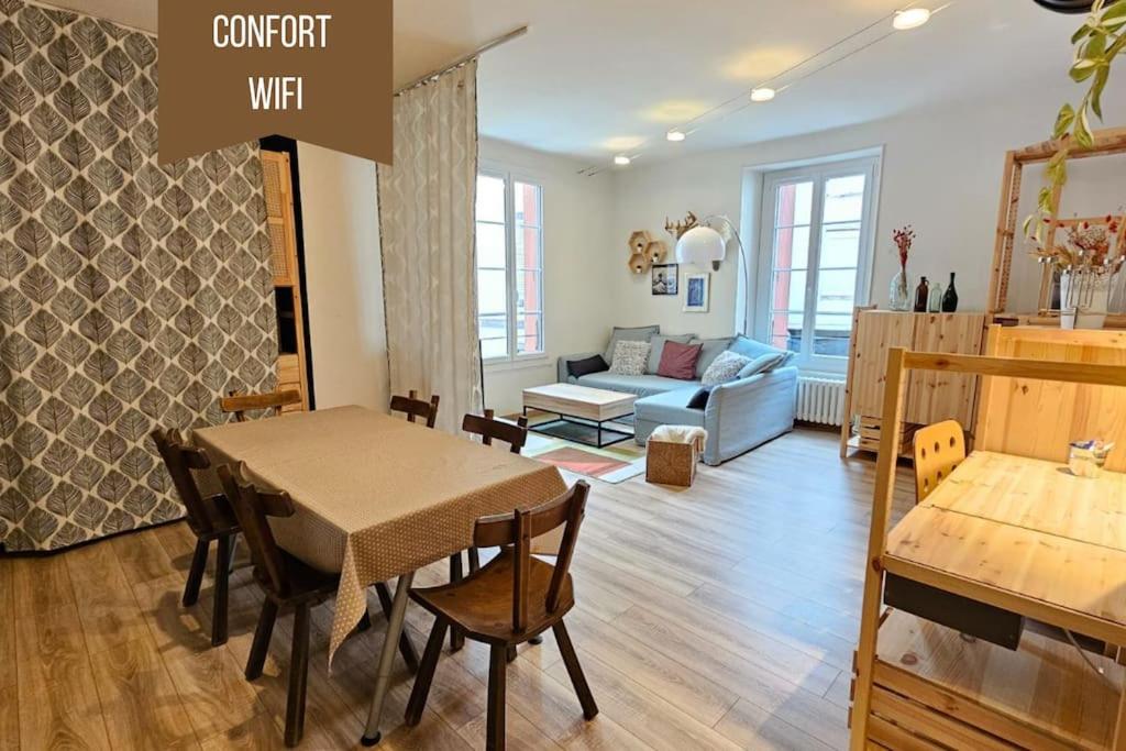 - un salon avec une table et un canapé dans l'établissement Le Royat Palace - Wifi - Confort, à Royat