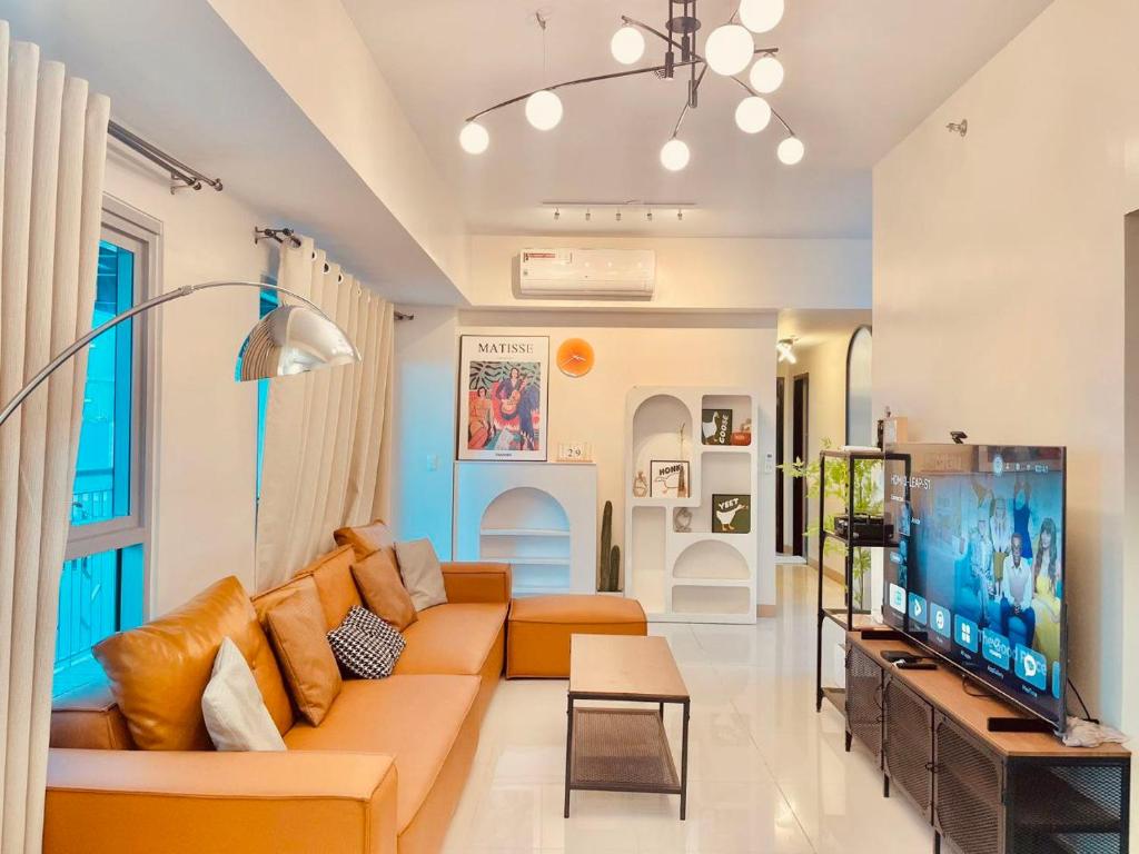 a living room with a couch and a tv at Bayshore 2 Residences in Manila