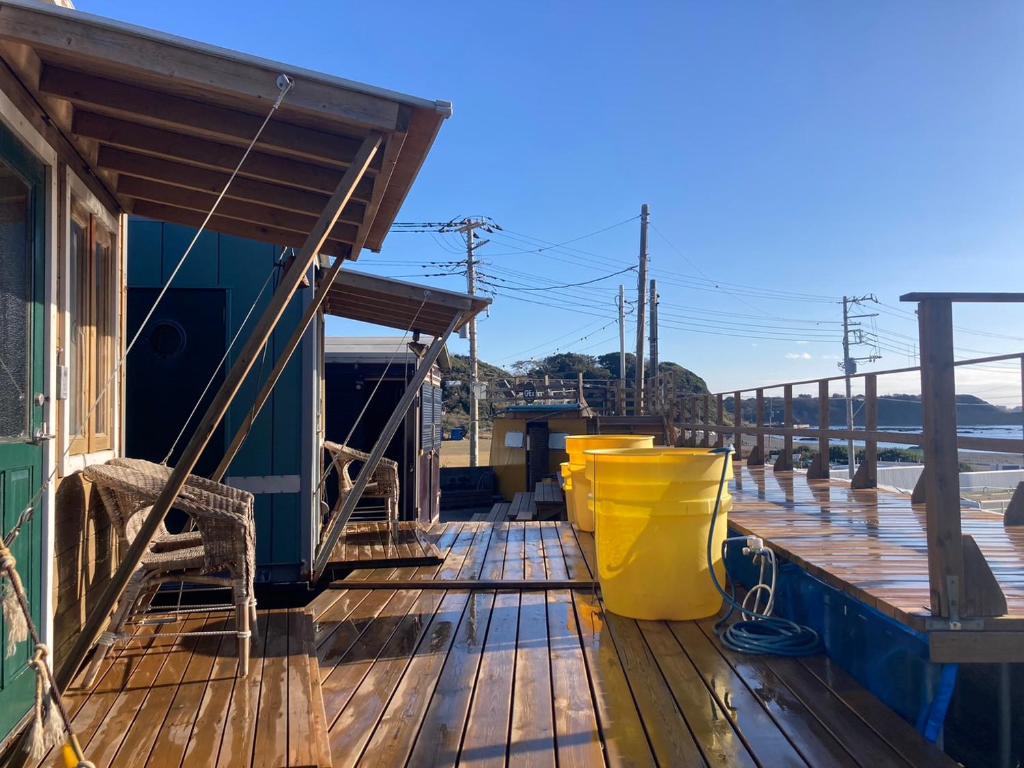 une terrasse en bois avec un seau jaune dans l'établissement The Galaxy Express Nahama ザ・ギャラクシー・エキスプレス・ナハマ, à Yokosuka