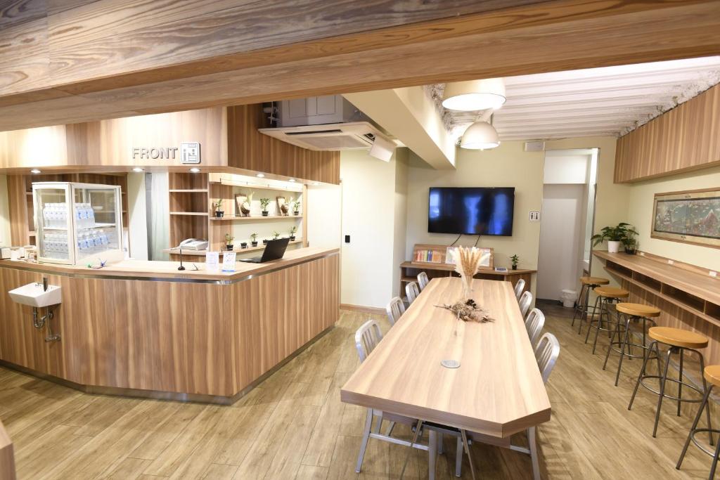 東京にあるA16 HOSTEL TOKYOのテーブルとバーのある待合室