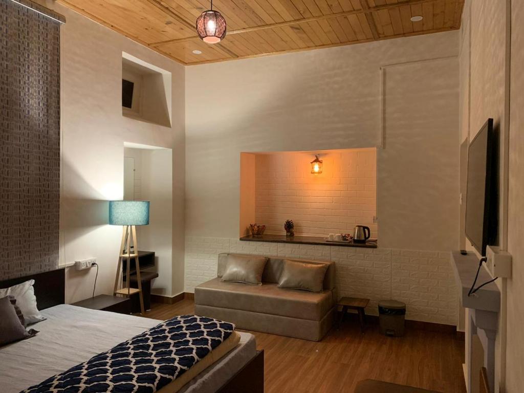 Carabean Villa في دالهوزي: غرفة بسرير واريكة وتلفزيون