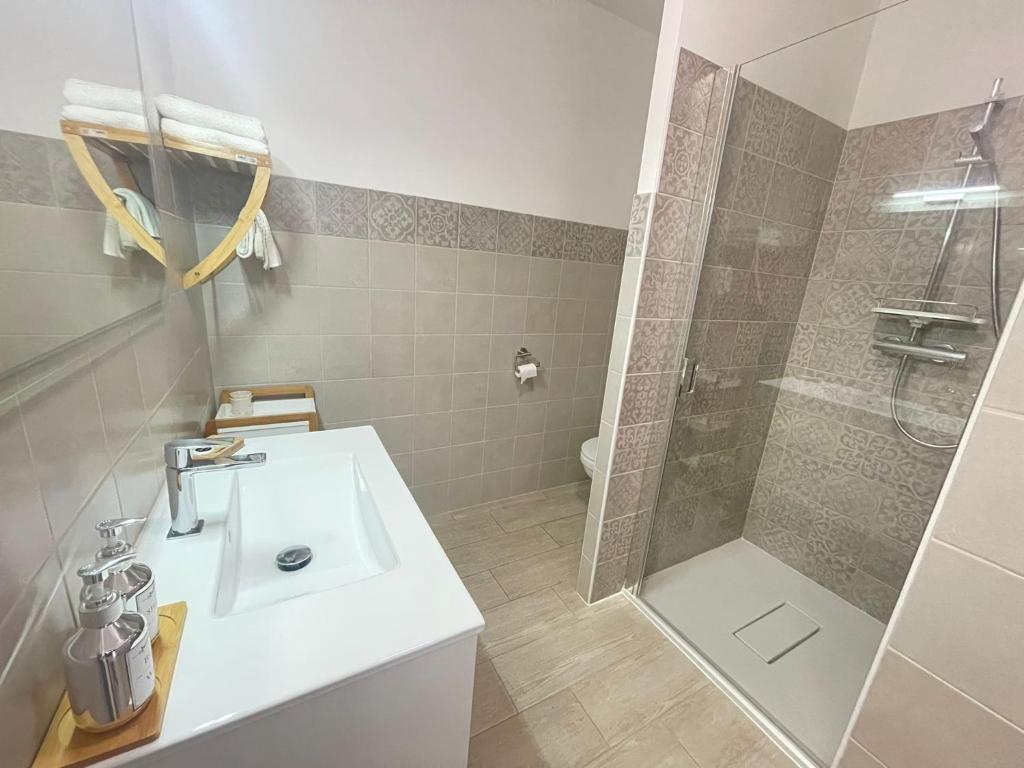 a bathroom with a white sink and a shower at Appartement Le Lido de la Marana in Lucciana