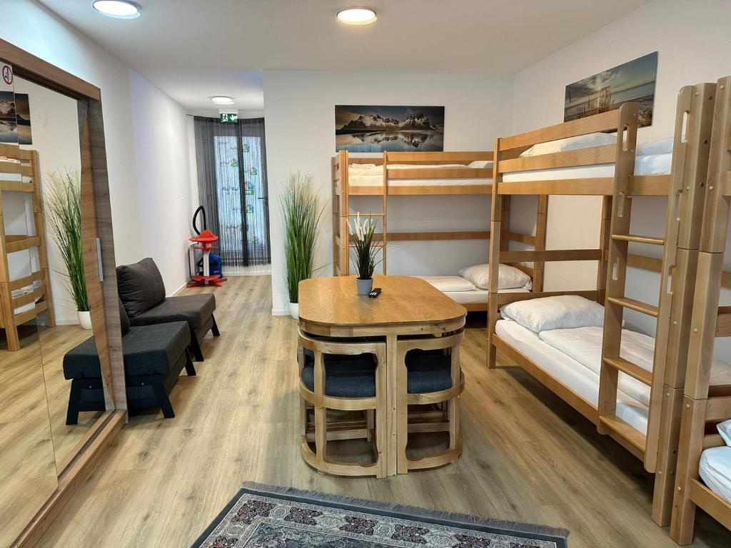 Cette chambre comprend des lits superposés, une table et un canapé. dans l'établissement Ferienwohnung in Center of Hamburg-Barmbek-Airport-4, à Hambourg