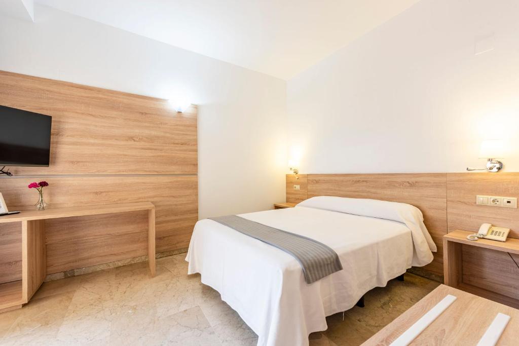 A bed or beds in a room at Hotel Toboso Almuñécar
