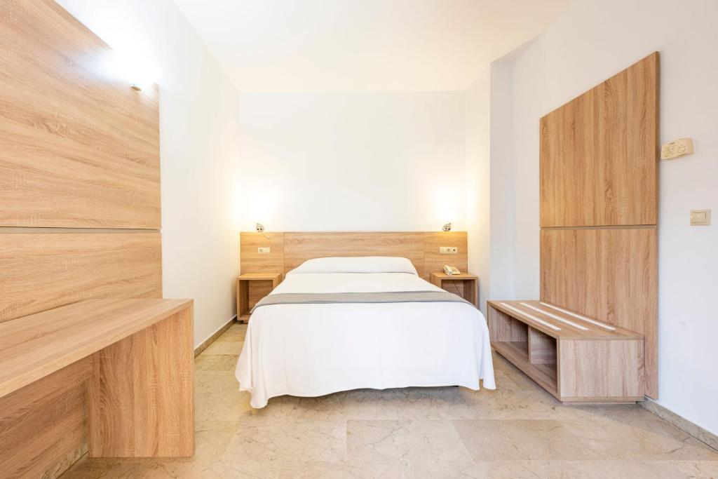 A bed or beds in a room at Hotel Toboso Almuñécar