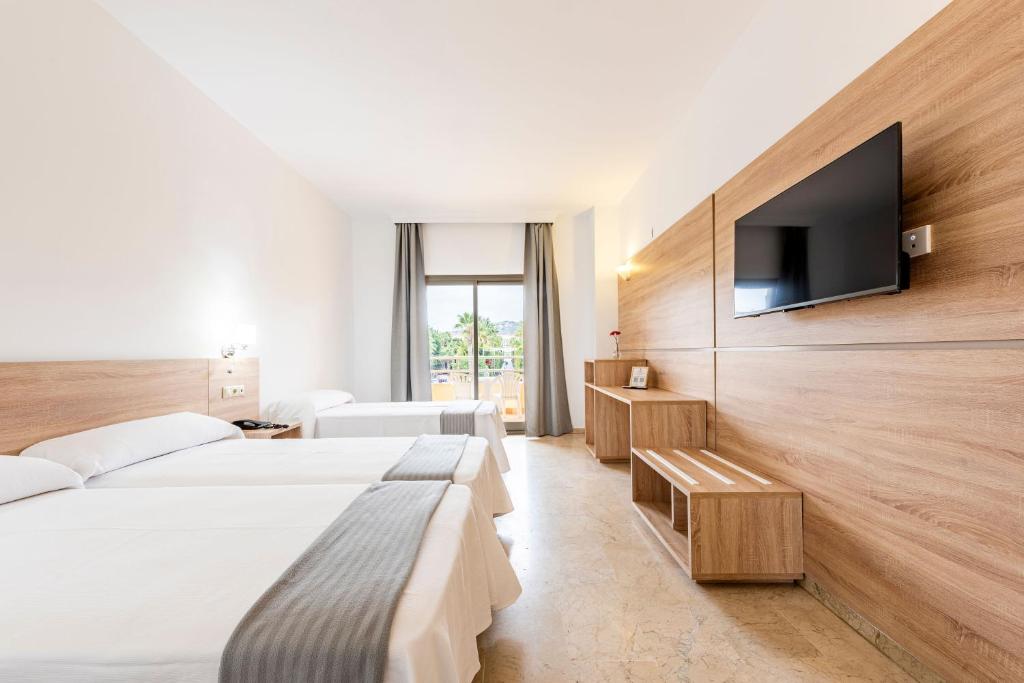 A bed or beds in a room at Hotel Toboso Almuñécar