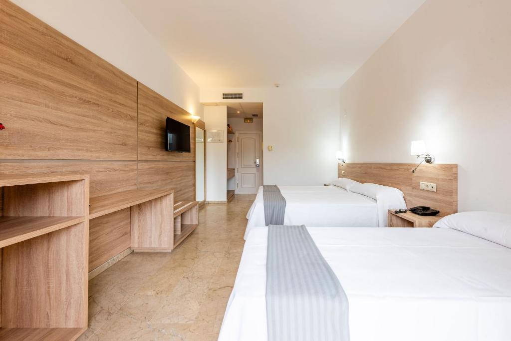 A bed or beds in a room at Hotel Toboso Almuñécar