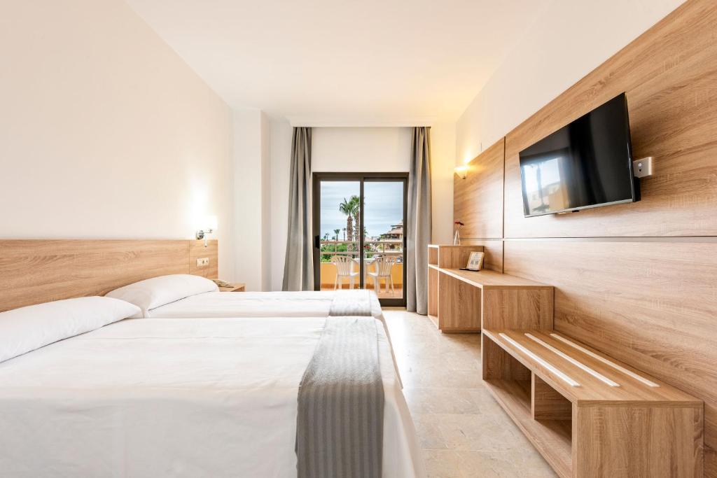 アルムニェーカルにあるHotel Toboso Almuñécarのベッド2台、薄型テレビが備わるホテルルームです。