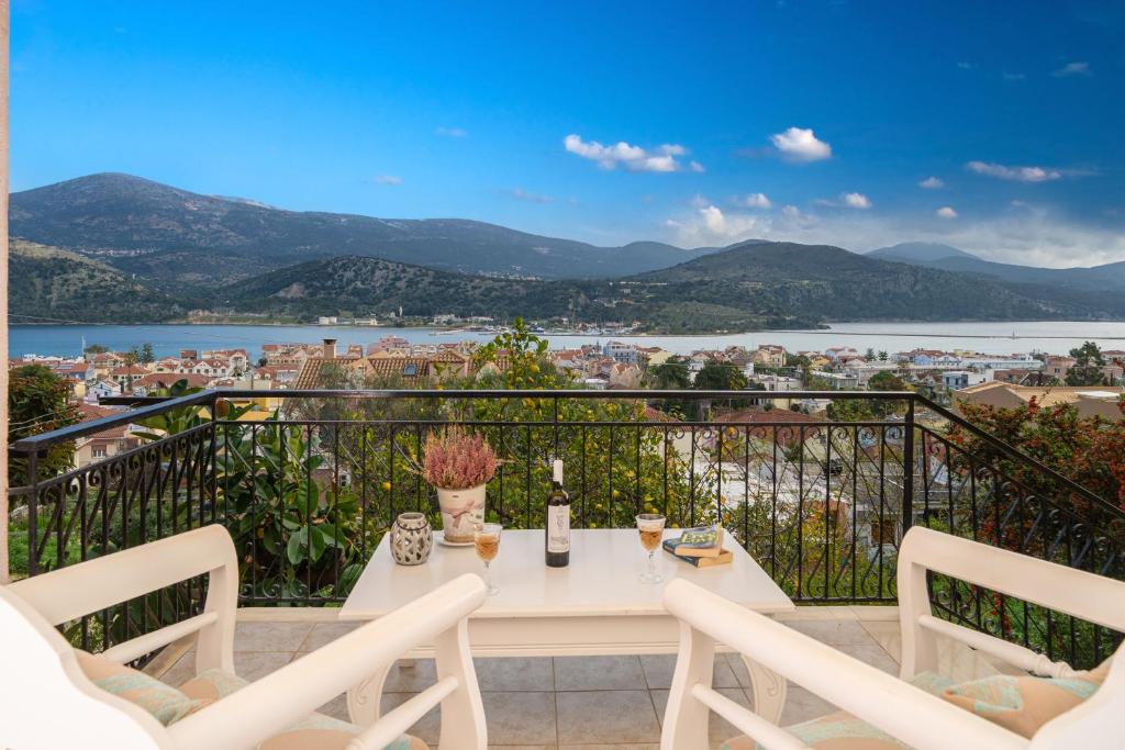 a white table and chairs on a balcony with a view at Aphrodite Superb Sea View Apartment in Argostoli