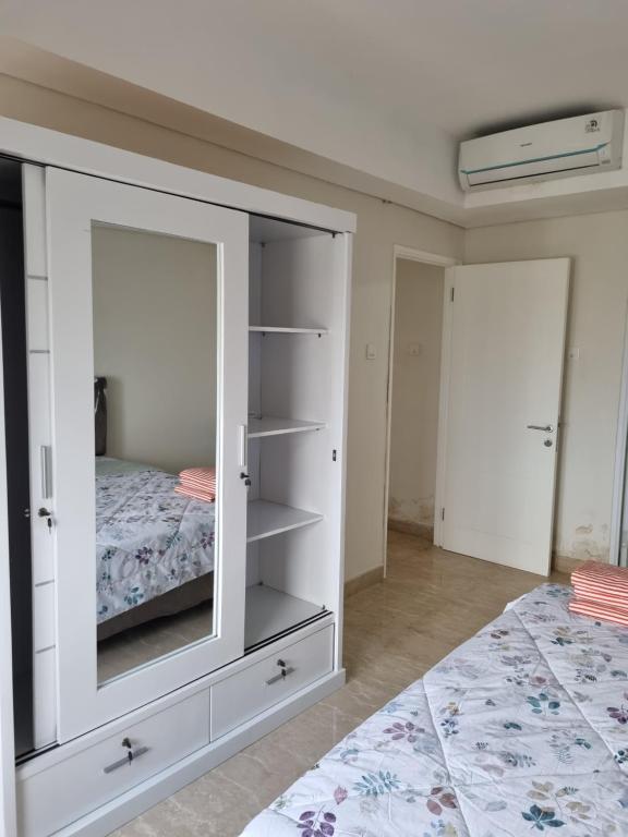 - une chambre dotée d'une armoire blanche avec un miroir dans l'établissement apartemen podomoro city medan, à Medan