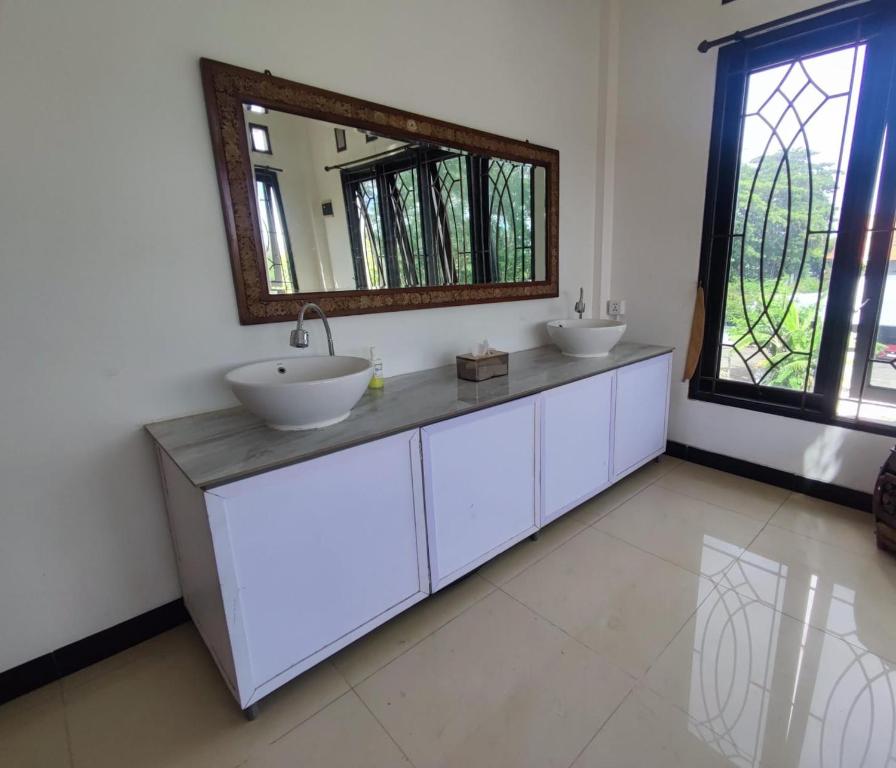 a bathroom with two sinks and a mirror at Fora Capsule Hostel Tuban Kuta Bali in Kuta