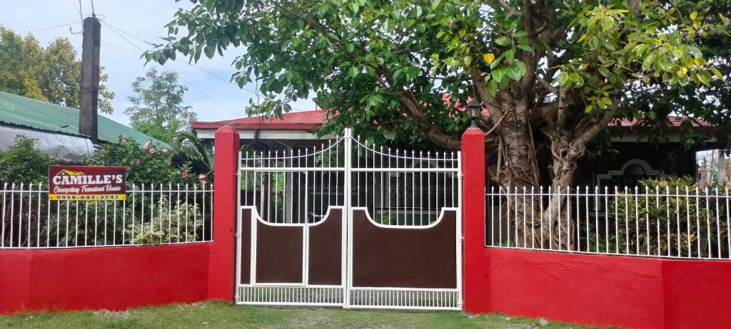 un portail rouge et blanc devant un arbre dans l'établissement Camille's Cheapstay, à Alaminos