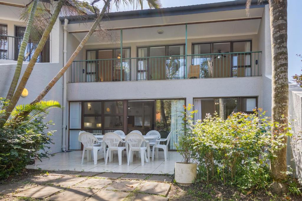 a house with a table and chairs in front of it at UNIT 1 @ Springvale Complex, Zinkwazi Beach in Zinkwazi Beach