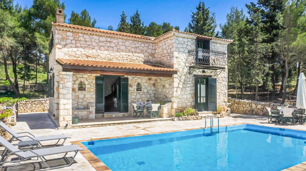 a villa with a swimming pool in front of a house at Villa Lida Aresti in Agios Leon
