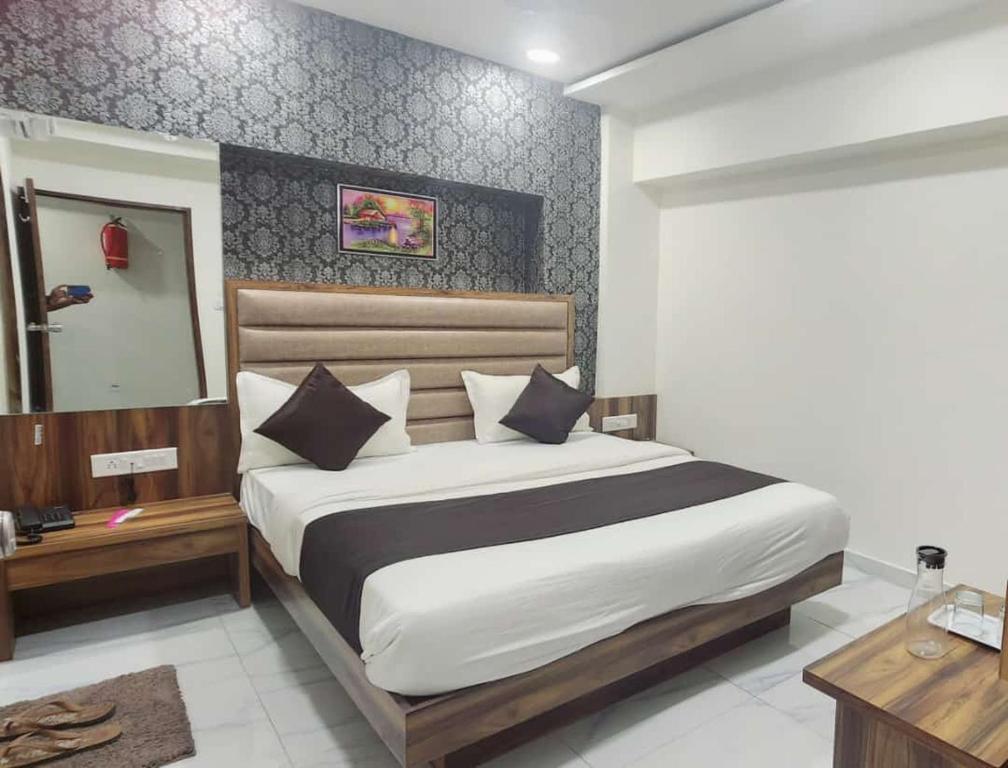 艾哈邁達巴德的住宿－Hotel Sun Shine，一间卧室配有一张大床和镜子