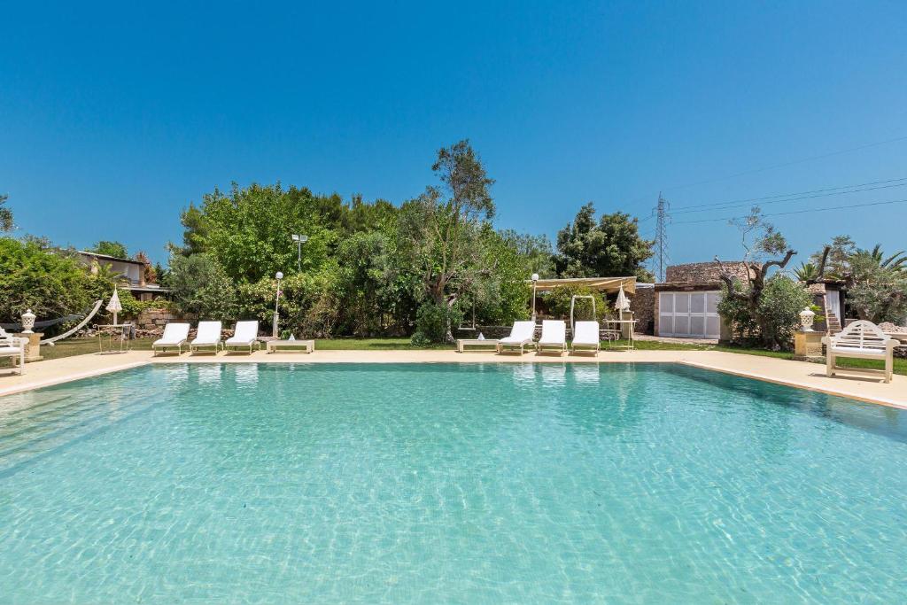 a large swimming pool with chairs in a yard at Masseria Cucuruzza Boutique Hotel in Felline