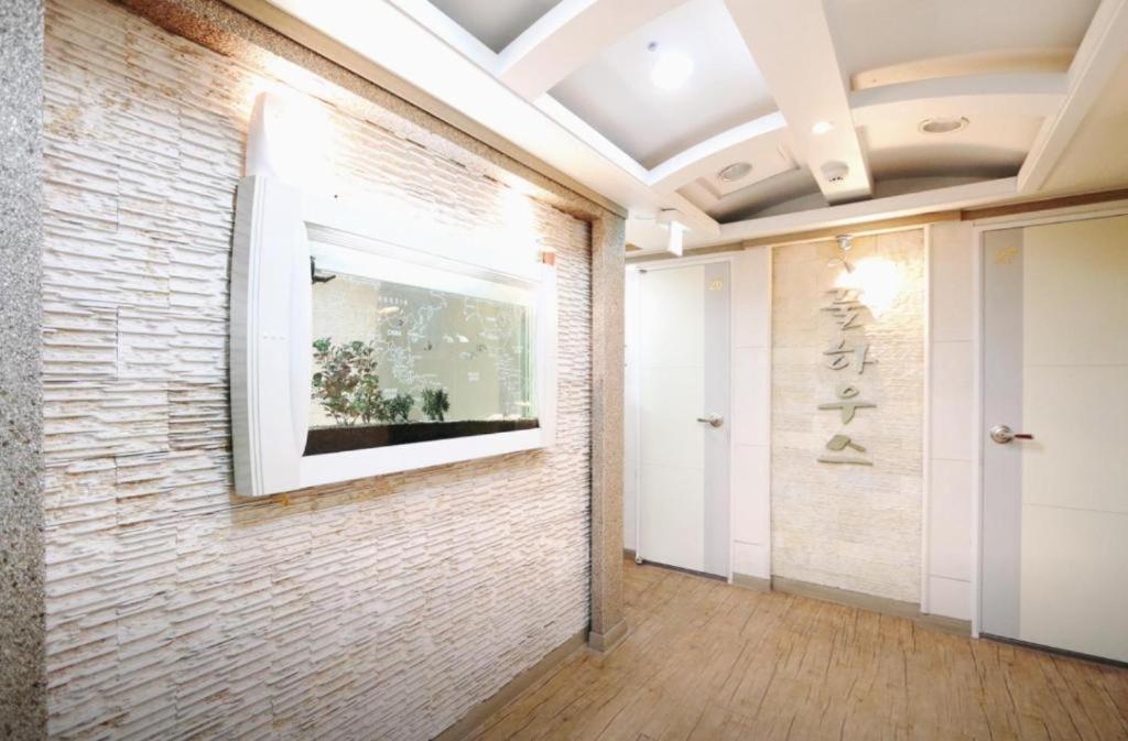 um corredor com uma parede de tijolos com uma televisão em Full House em Seul