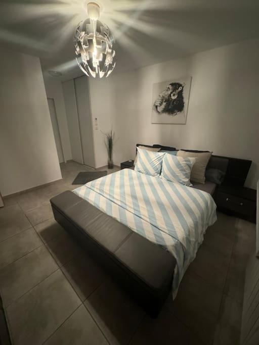 Schlafzimmer mit einem Bett und einem Kronleuchter in der Unterkunft Villa de vacances avec piscine privative chauffée in Saint-Maime