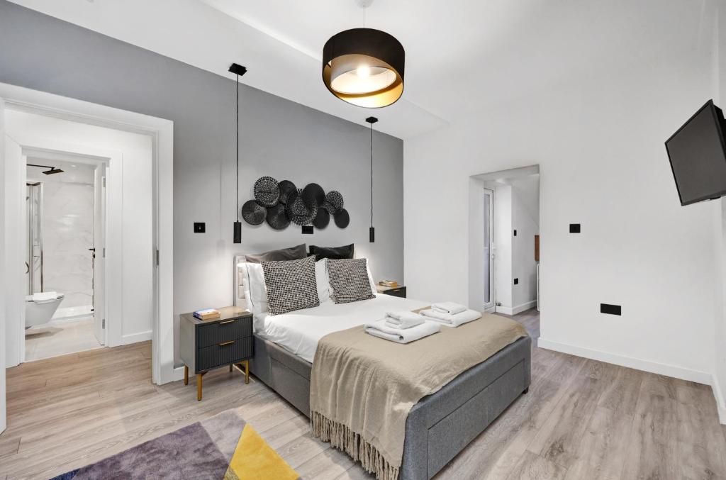 a bedroom with a large bed and a bathroom at Hilldrop Apartments in London