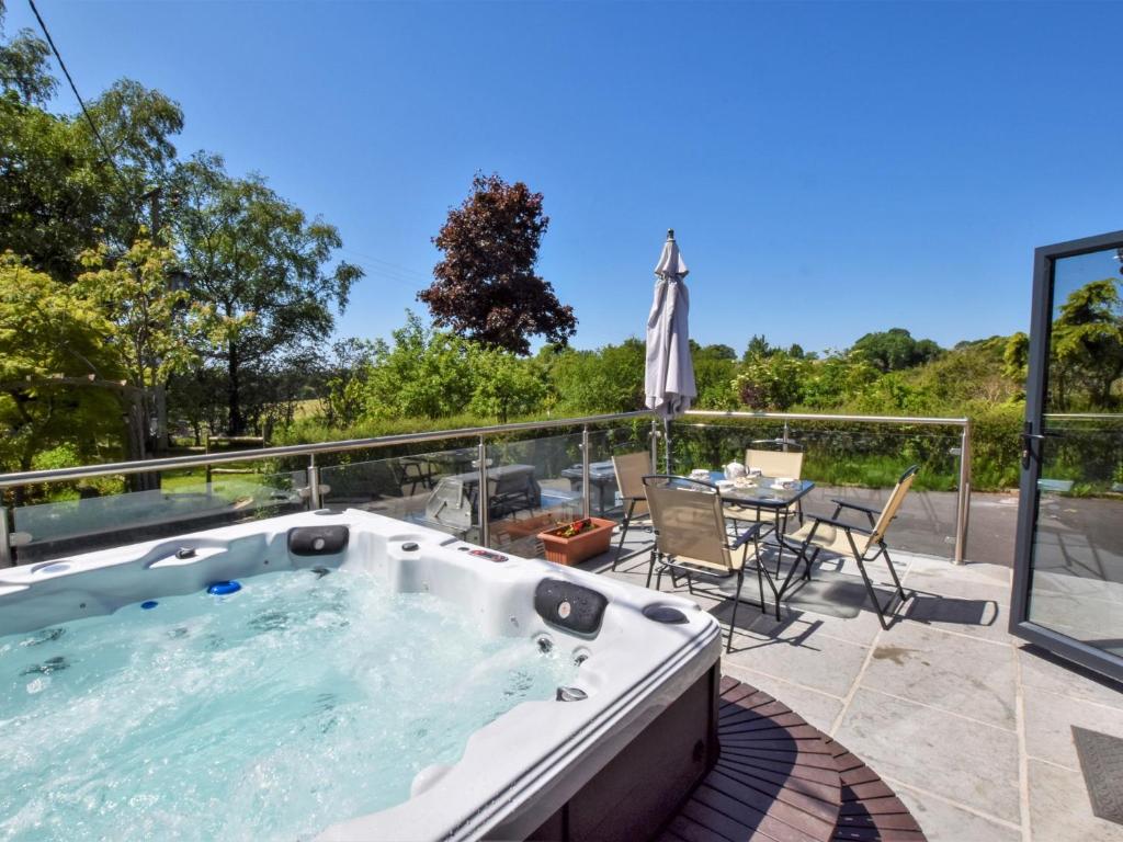 a hot tub on a patio with a table and chairs at 2 Bed in Pendle 91032 in Brierfield