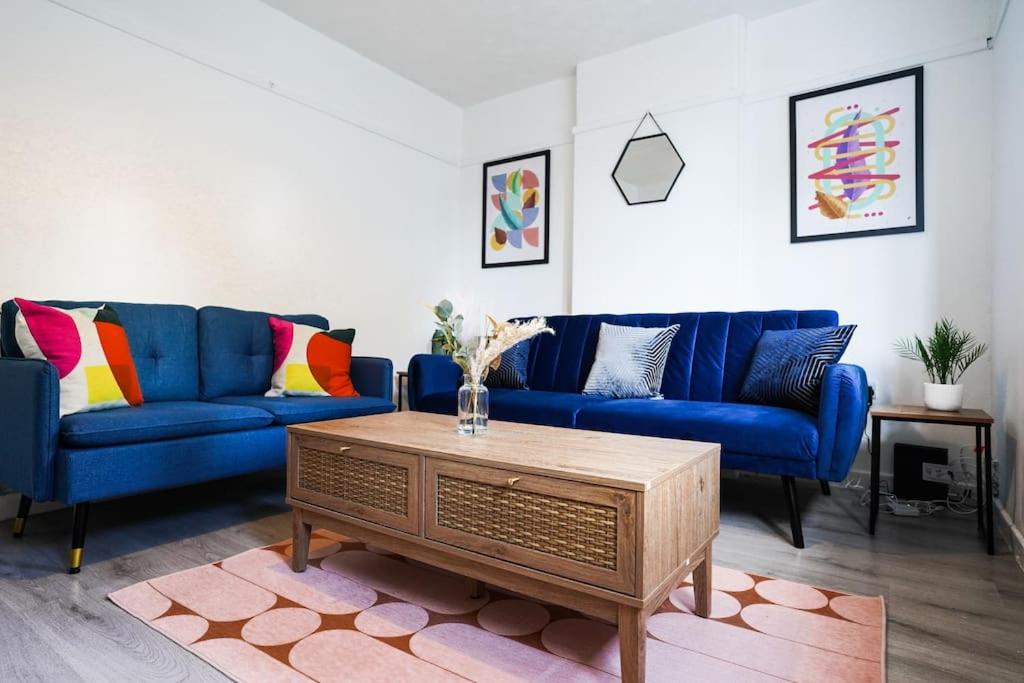 a living room with blue couches and a coffee table at Stylish 3-Bed Home near Anfield with Parking in Walton on the Hill
