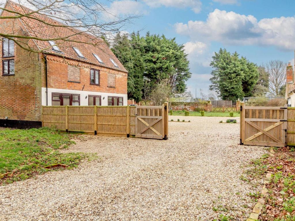 a house with two wooden gates in front of a house at 2 Bed in Reedham 90882 in Cantley