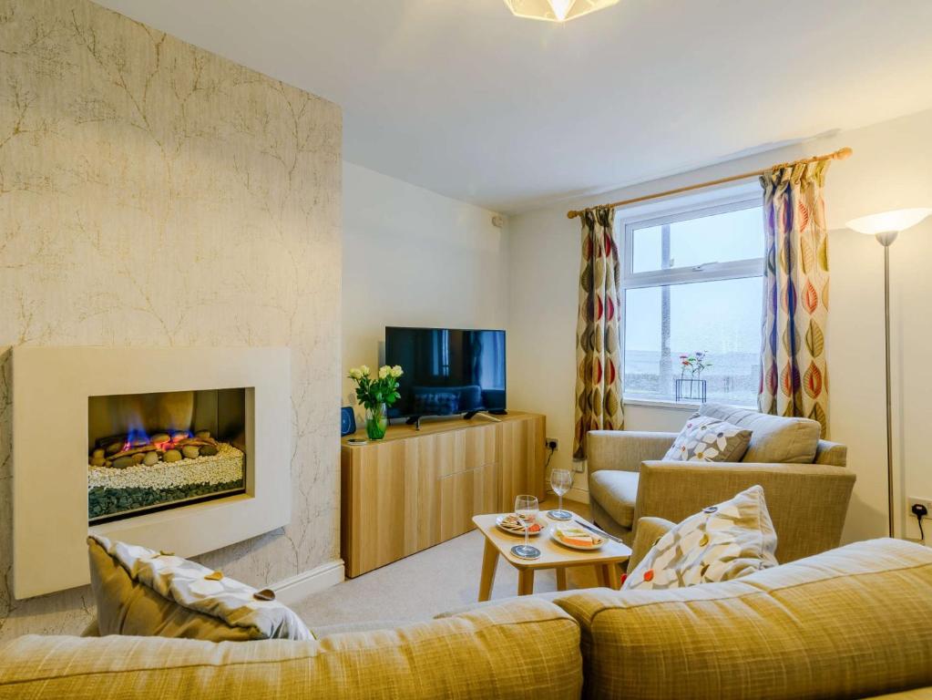 a living room with a couch and a fireplace at 1 Bed in Holmfirth 91106 in Cartworth