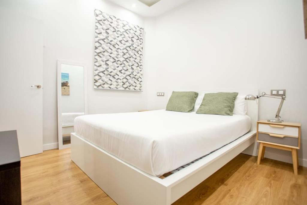 a white bedroom with a white bed and a lamp at Ideal flat in the Retiro area - C5 in Madrid