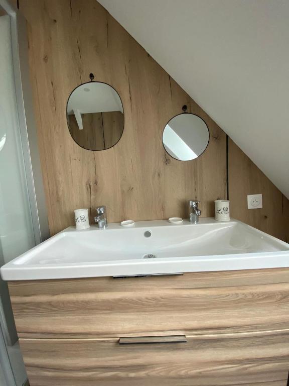 a bathroom with a large tub and two mirrors at Hôtel du Musée in Granville