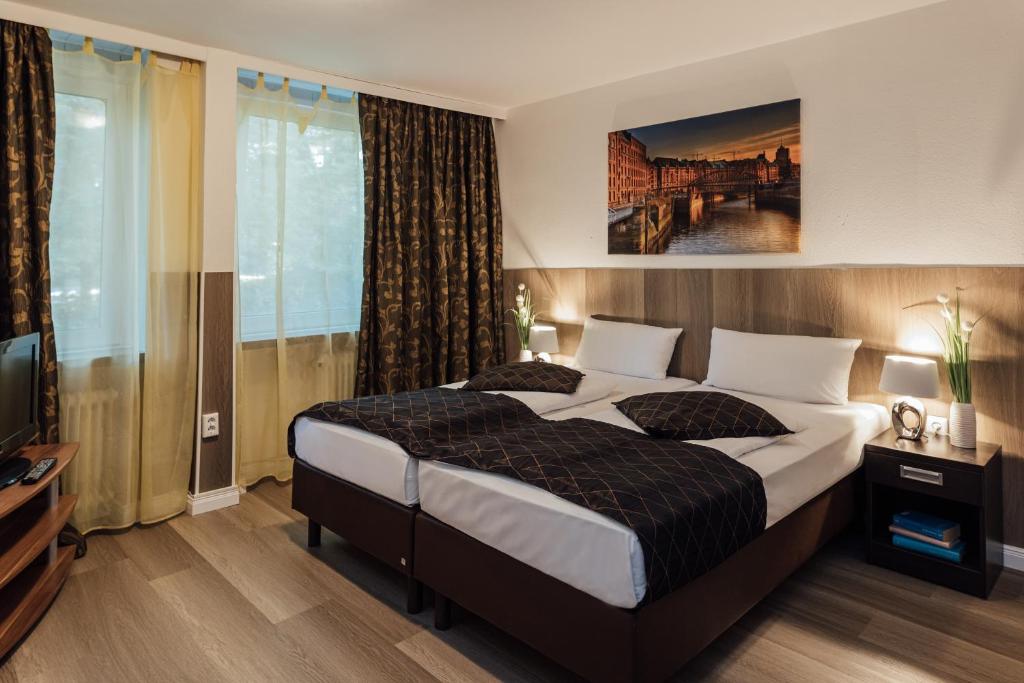 a bedroom with a large bed and a television at Hotel Hanseat Hamburg in Hamburg