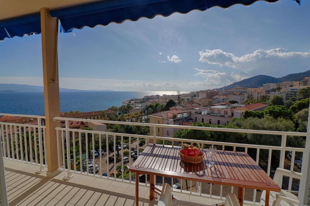 un balcon avec une table et une vue sur l'océan dans l'établissement Appartement centre ville Les Pins Ajaccio, à Ajaccio
