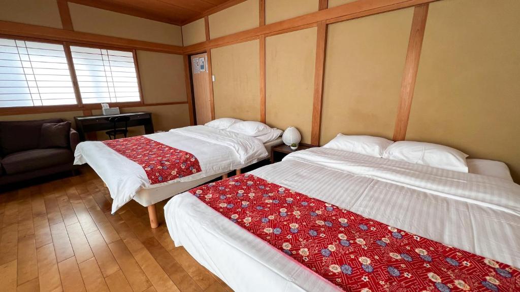 um quarto com duas camas e um sofá em Hondori Inn em Hiroshima