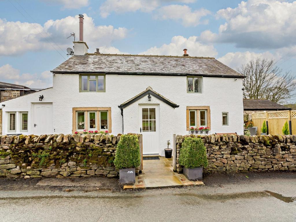 a white house with a stone wall at 2 Bed in Skipton 91296 in Bolton Bridge