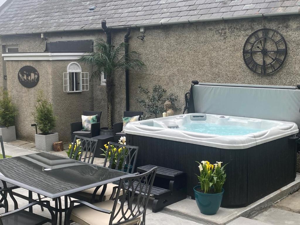 a hot tub on a patio with a table and chairs at 4 Bed in Wick 91390 in Wick