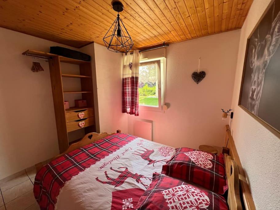 - une chambre dotée d'un lit avec une couverture rouge et blanche dans l'établissement O' Chênes Rouges GERARDMER - 4-6 pers avec terrasse vue lac et montagne, à Gérardmer