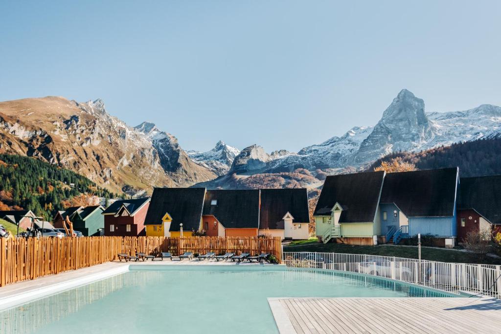 a swimming pool with mountains in the background at ISKÖ BaseCamp & Hôtel, Col d'Aubisque in Gourette