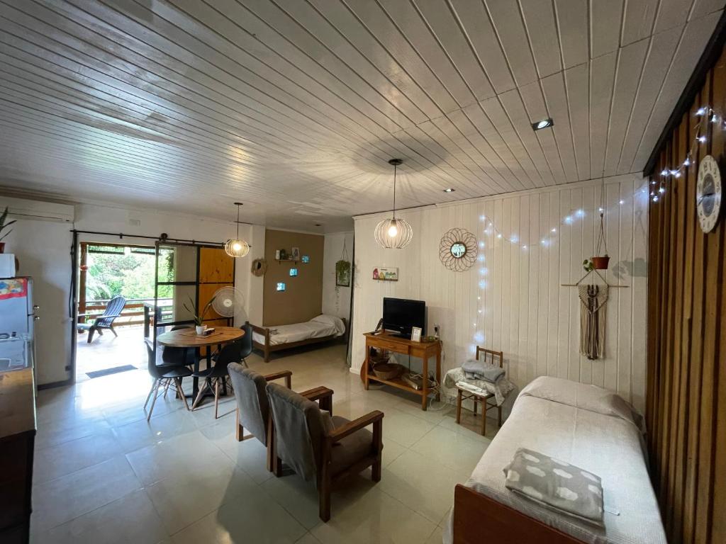 ein Wohnzimmer mit einem Bett und einem Esszimmer in der Unterkunft Casa Araucarias Refugio Natural en la Ciudad in Posadas