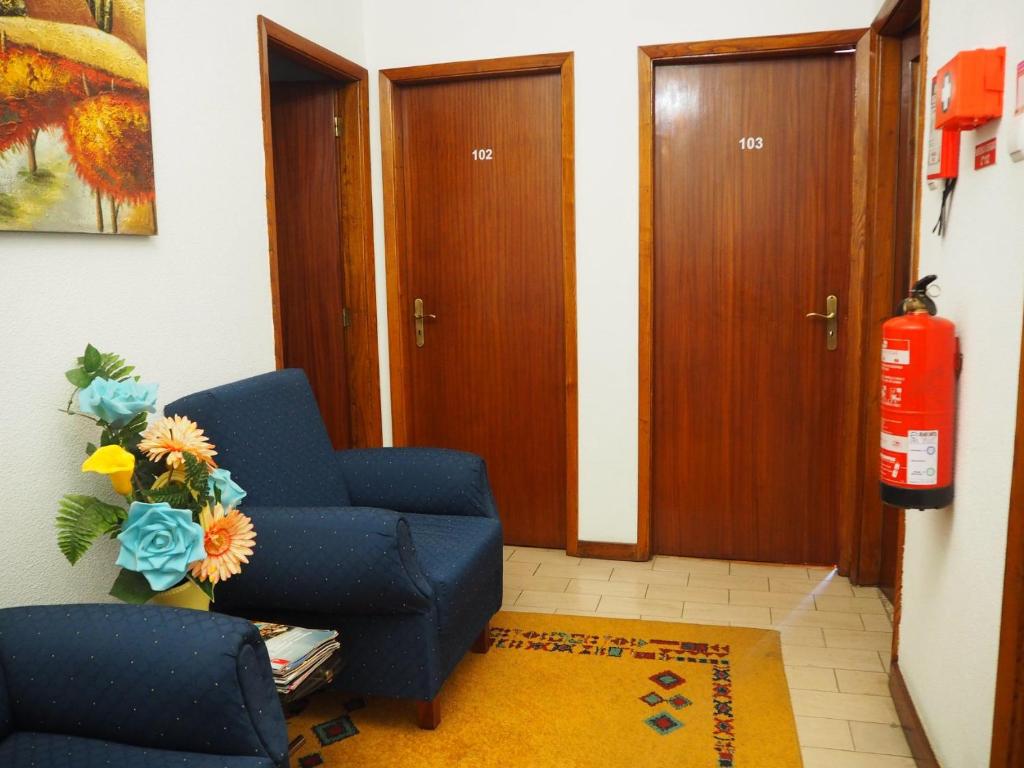 salon z niebieskim krzesłem i gaśnicą w obiekcie Monte Carlo - Alojamento Local w mieście Pedras Salgadas