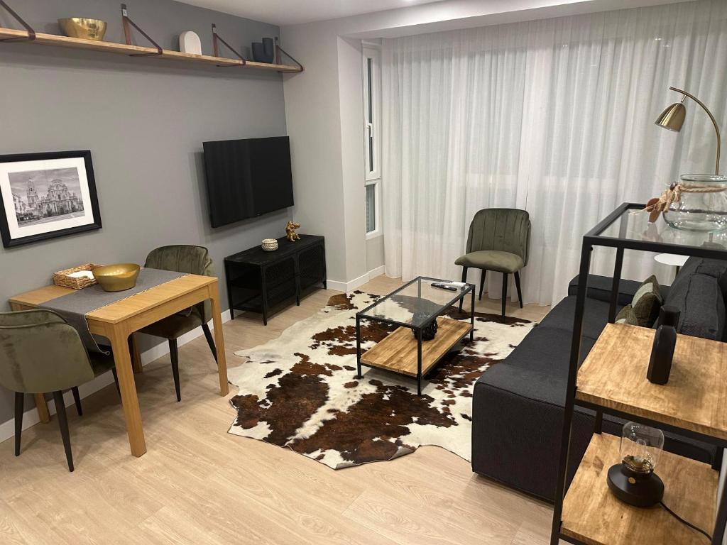 uma sala de estar com um sofá e uma mesa em Apartamentos Universidad em Múrcia