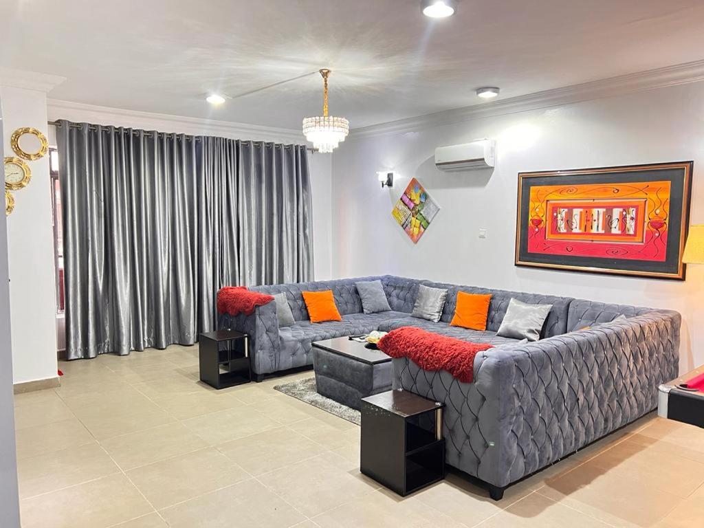 a living room with a gray couch and a table at Tribeca pod (3 bedroom with swimming pool) V.i Lagos in Lagos