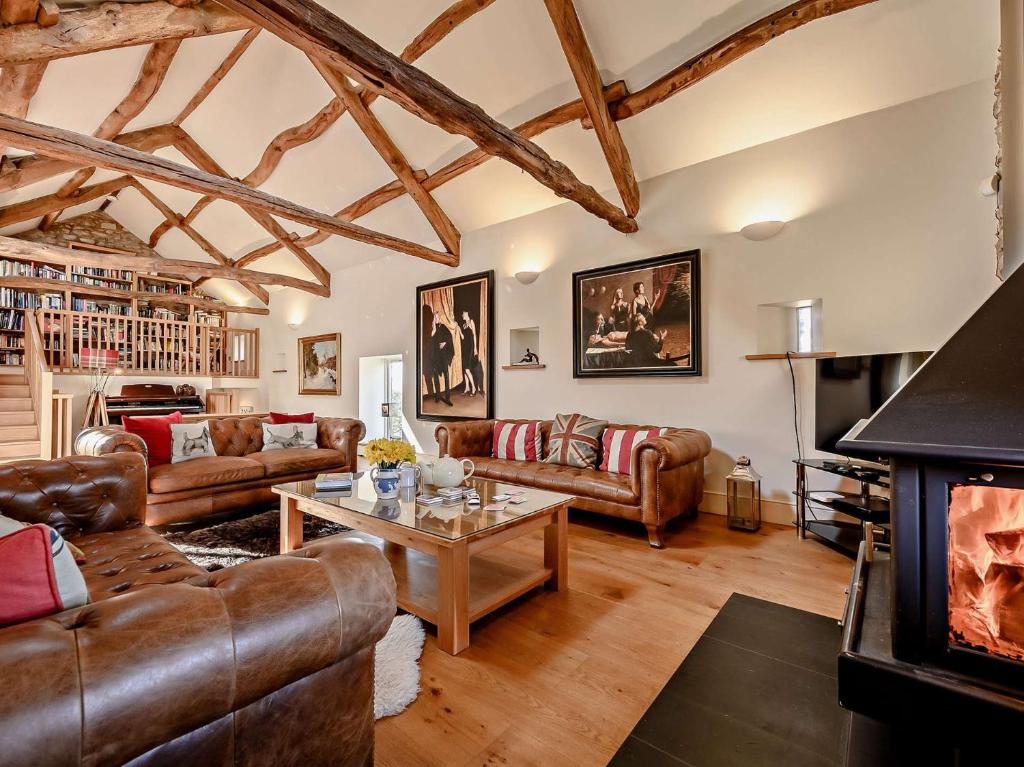 uma sala de estar com mobiliário de couro e uma lareira em 5 Bed in Keswick 91503 em Embleton