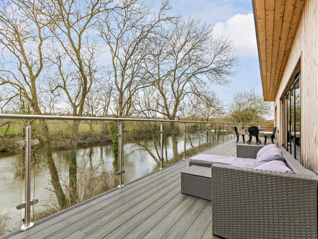 a wooden deck with chairs and a view of a river at 4 bed property in Worcester 91592 in Worcester